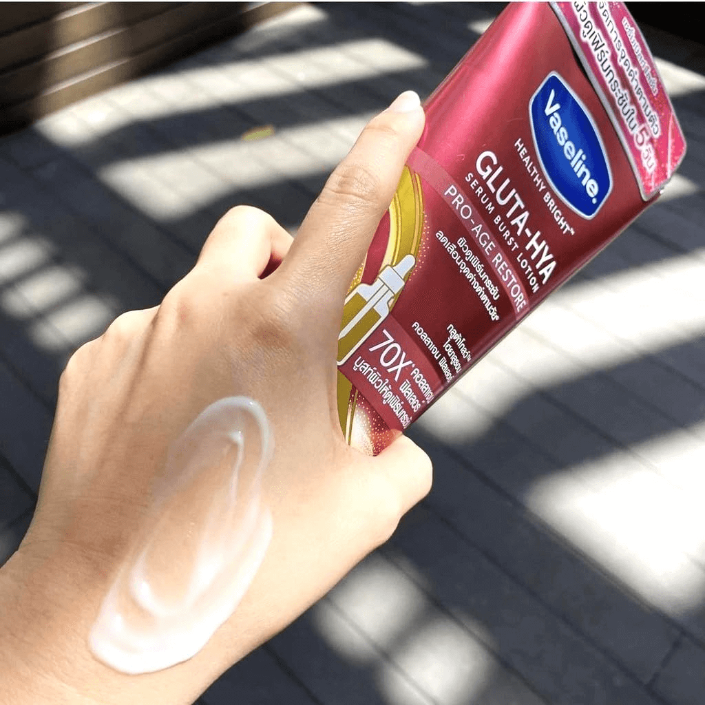 Hand applying Vaseline Gluta-Hydra Pro-Age Restore lotion on a sunlit surface
Vaseline Serum Burst Lotion Pro-Age Restore with a hand applying lotion to lips.