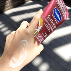 Hand applying Vaseline Gluta-Hydra Pro-Age Restore lotion on a sunlit surface
Vaseline Serum Burst Lotion Pro-Age Restore with a hand applying lotion to lips.